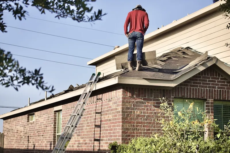 Professional roofer working on a residential roof in Pond Village